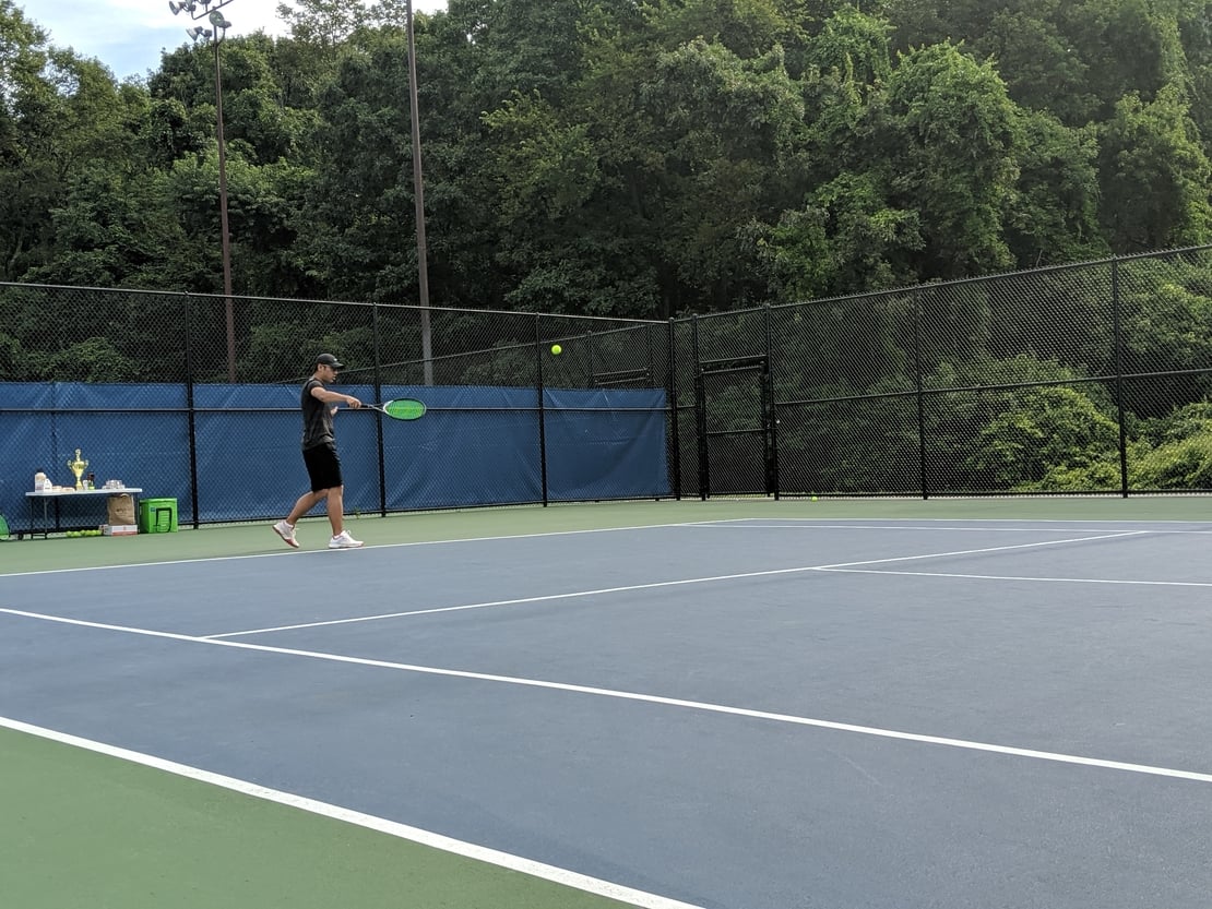 first round tennis player hitting a backhand slice