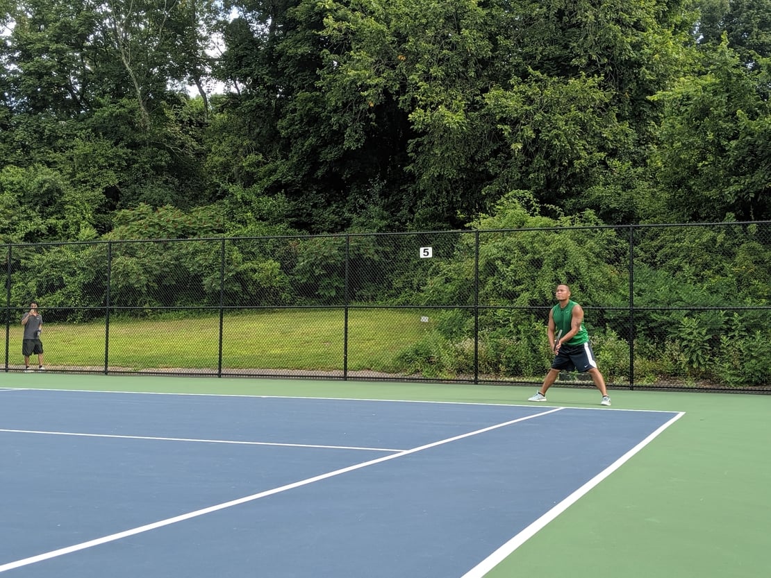 first round tennis player waiting to return a serve