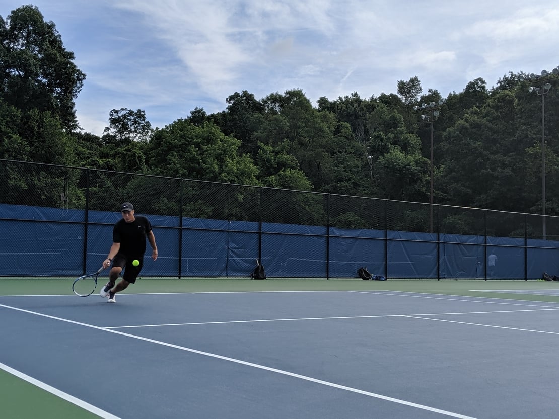 first round tennis player hitting an approaching forehand