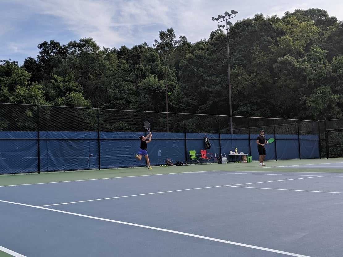 first round tennis player returning a high lob